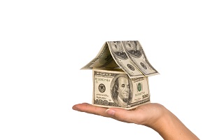 person holding house made of money